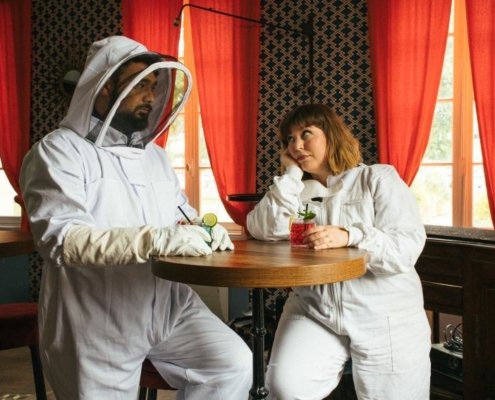 portrait du duo Part-Time Friends prenant un verre de soda en tenue d'apiculteur