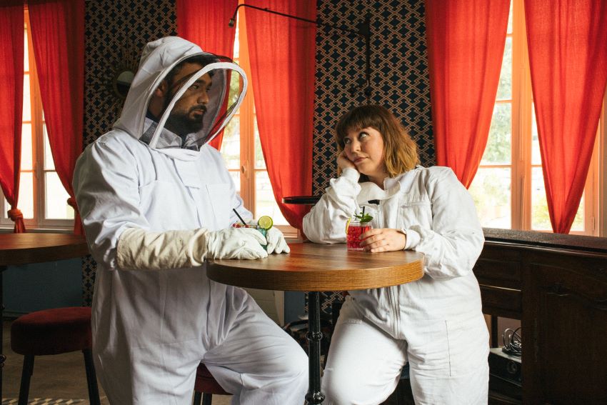 portrait du duo Part-Time Friends prenant un verre de soda en tenue d'apiculteur