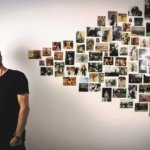 Thomas Cousin regardant des photos au mur pour la sortie de son premier album solo