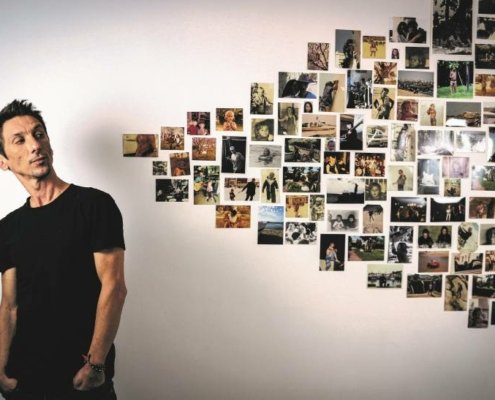 Thomas Cousin regardant des photos au mur pour la sortie de son premier album solo