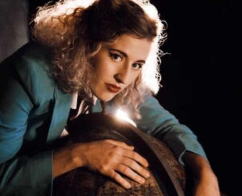 L'artiste Mary Bach est penchée sur un globe en tailleur bleu