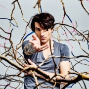 portrait de Louis Arlette tendant la main dans des branchages