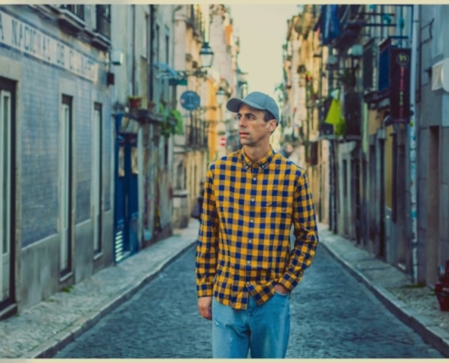 portrait de Le Daron prise en pleine rue avec une casquette et une chemise à carreau