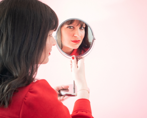 portrait avec reflet dans un petit miroir du visage de l'artiste June Milo
