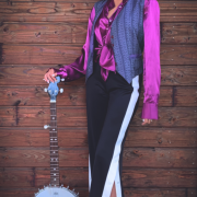 portrait en pied de l'artiste ALBA avec un banjo
